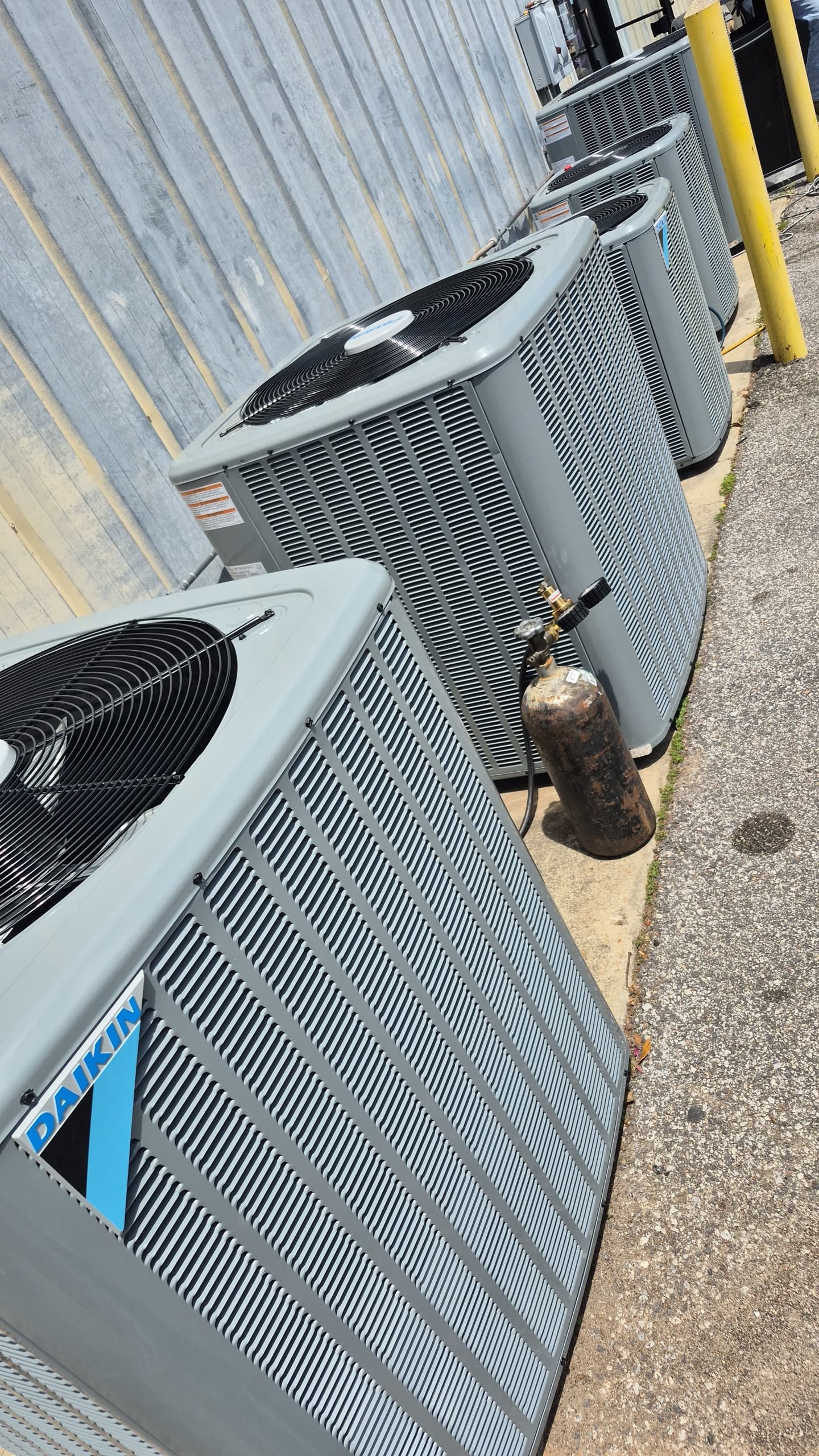 Row of outdoor condensing units installed along an exterior wall